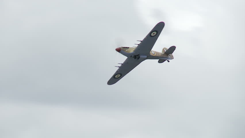 Hawker Hurricane fighter plane from World War II flying in cloudy sky.  Recorded