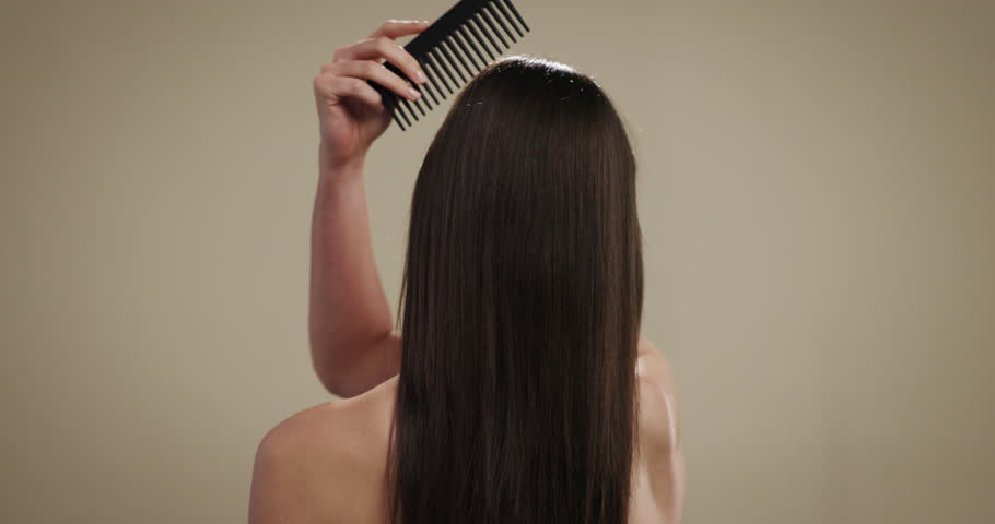 Back, hair care and comb with woman in studio for salon treatment, volume and growth. Shine, shampoo and hairdresser tools with person on background for aesthetic, cosmetics and keratin glow