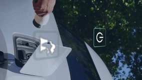 Animation of eco icons over man charging electric car. Global green energy, environment, connections, computing and data processing concept digitally generated video. - Powered by Shutterstock - Get 15% off with code: PIKWIZARD15