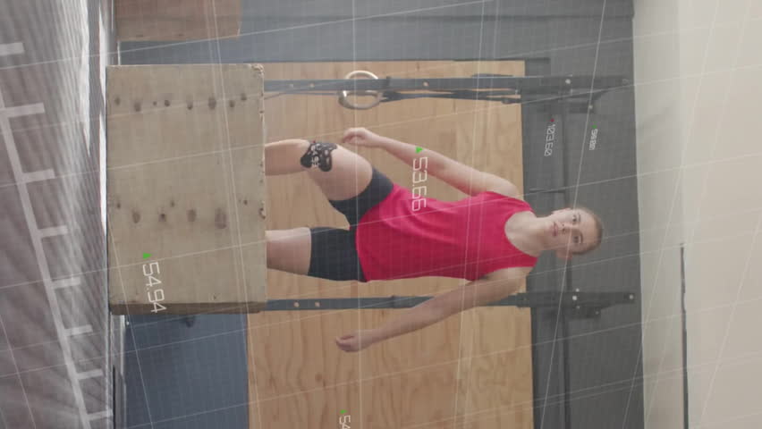 Red line graph animation over woman standing on wooden box in gym. Fitness, workout, exercise, data, training, strength - Powered by Shutterstock - Get 15% off with code: PIKWIZARD15