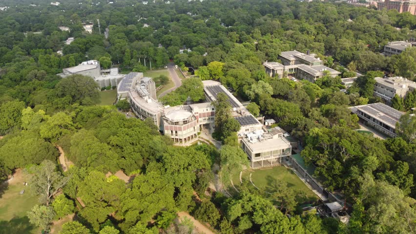 Aerial view of buildings nestled amidst a dense canopy of trees, showcasing a harmonious blend of architecture and nature, New Delhi, Delhi, India.