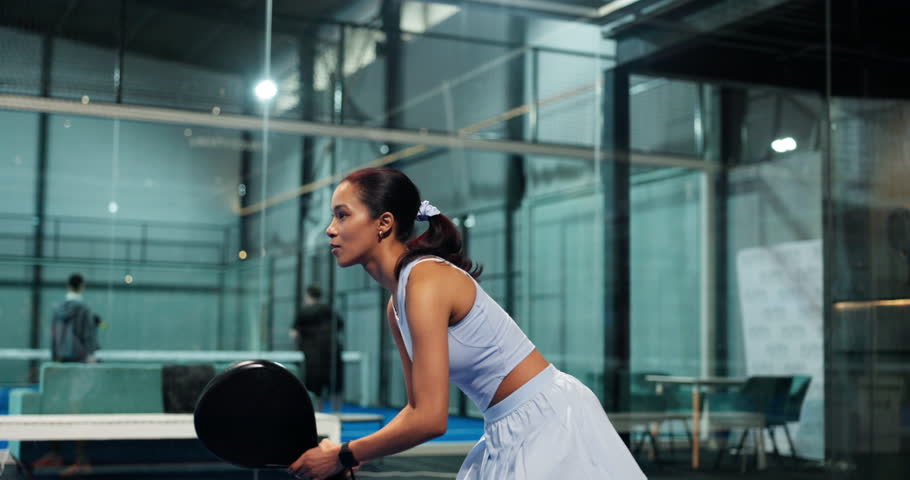 Sports, woman and playing padel on court for match practice, game training and serving ball. Fitness, tennis player and ready with racket at indoor club for technique exercise, performance and energy