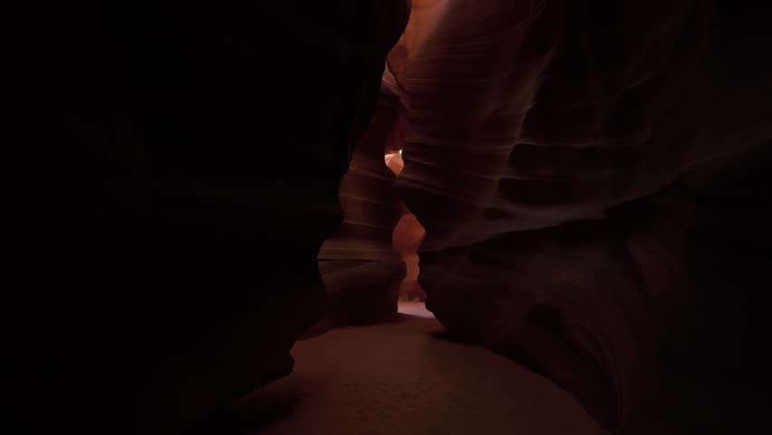 Antelope Canyon narrow passageway, showcasing intricate rock formations with vibrant red and orange hues, illuminated by natural light filtering through the canyon.