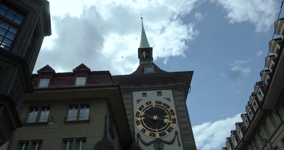 Old clock tower in Bern showcases intricate design under a cloudy sky