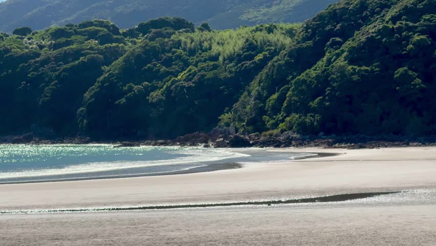 Low tide view at Ohama Beach, Fukue Island, Goto Islands, Nagasaki Prefecture, Japan – wide sandy beach, rocky shoreline, and shimmering turquoise sea under a clear summer sky.