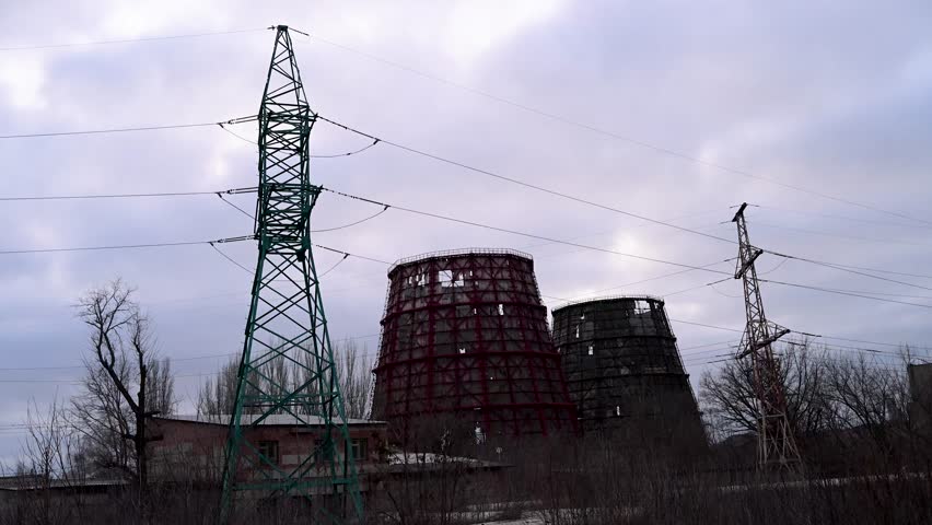 A power plant's cooling towers destroyed by a Russian missile strike in Kramatorsk, Ukraine. Dusk view of war-torn energy infrastructure on the Donbas frontline during the ongoing conflict.