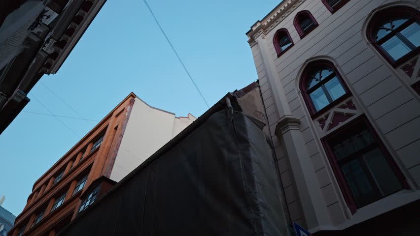 Exploring Urban Architecture with Tall Buildings Standing Under a Bright Blue Sky on a Beautiful Day