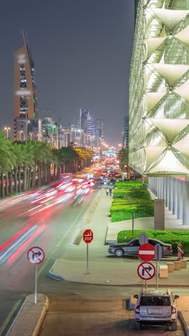 Aerial night timelapse of King Fahd Road in Riyadh, Saudi Arabia. Bustling busy traffic with cars near the illuminated Riyadh National Library, surrounded by modern towers and skyscrapers