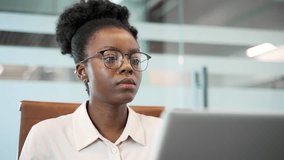 Thoughtful african american businesswoman typing on laptop sitting at desk at workplace in business office. Black woman employee works on a computer on a project or is busy with a task. Close up - Powered by Shutterstock - Get 15% off with code: PIKWIZARD15