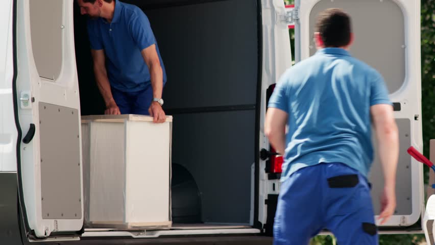House Relocation. Men Unloading From Truck For Delivery