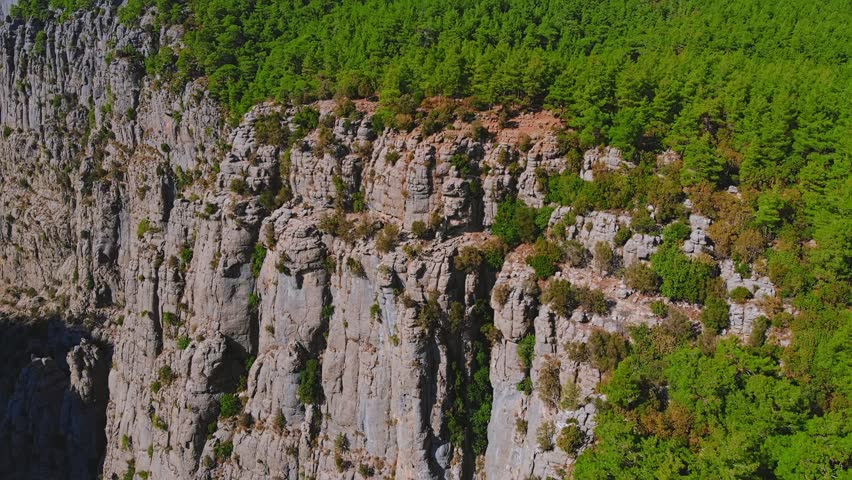 Traveler hiker on rocky cliff edge overlooking vast Tazi Canyon landscape in Manavgat, Antalya, Turkey.