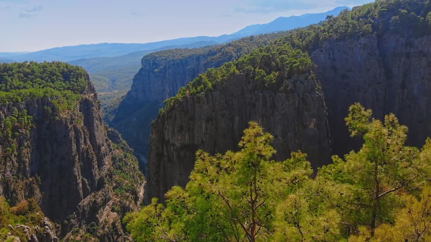 Adventurous hiker on rocky cliff edge overlooking vast Tazi Canyon landscape in Manavgat, Antalya, Turkey.