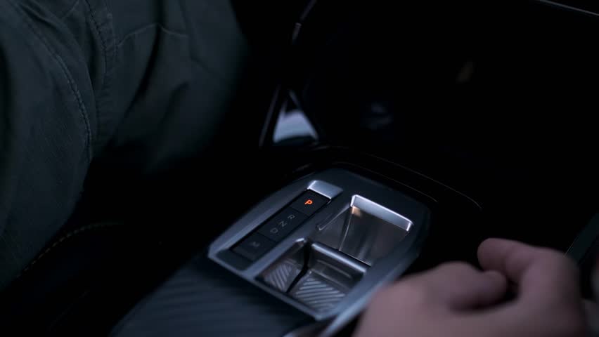 Detailed close up video showing driver's hand changing gears in modern automatic transmission vehicle