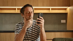 Man using mobile phone at home in kitchen, 4K with selective focus - Powered by Shutterstock - Get 15% off with code: PIKWIZARD15