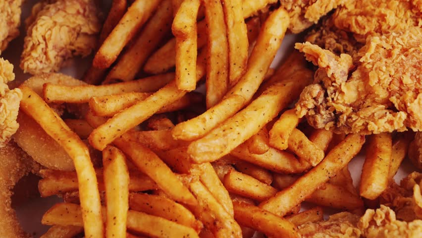 Delicious set of french fries, chicken wings, nuggets and onion rings. Fast food concept. High quality 4k footage