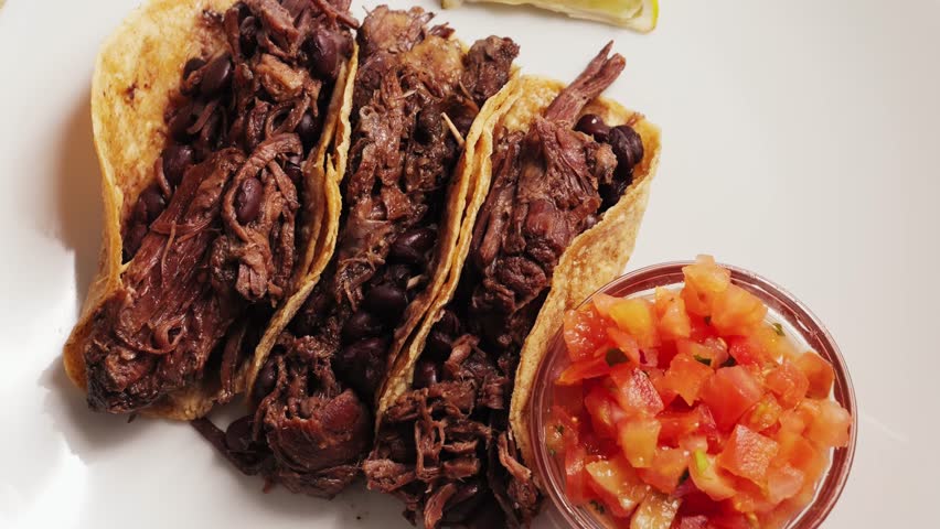 Traditional Mexican food tacos with pulled pork or beef, beans served with Mexican sauce Pico De Gallo, spicy hot sauce made from diced tomatoes, onions and jalapeno peppers. High quality 4k footage