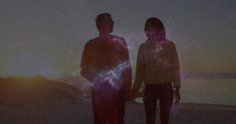 Film couple walking on beach sharing glance approaching center shimmering nebula flare backlighting. Romantic, silhouette, celestial, atmospheric, serene, harmony, adventure