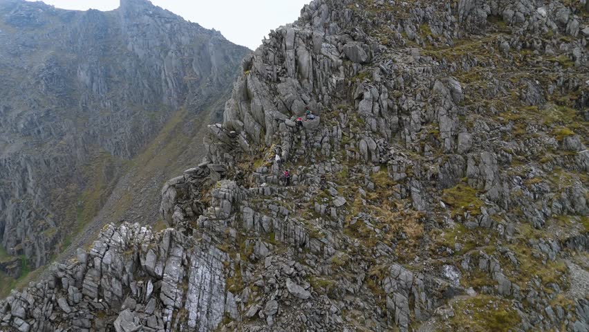 Climbers and hikers ascending Y Gribin in Snowdonia, grade 1 scramble with rocky exposure to Glyder Fawr and Glyder Fach in Eryri National Park Wales.