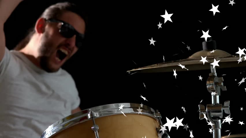 Drummer raising arm and shouting initiating cymbal strike releasing star confetti for music promo. Performance, celebration, energy, rhythm, spectacle, intensity, stage