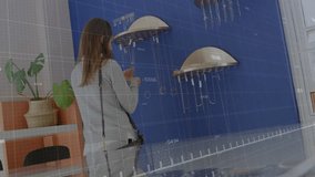 Woman entering key-management showroom and tracing green graph over key holders for data insight. Technology, security, innovation, analytics, progress, business, modern - Powered by Shutterstock - Get 15% off with code: PIKWIZARD15