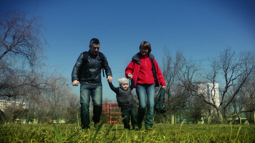 Happy familly running in the park, slow motion