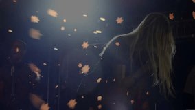 Spotlight cueing woman singer leaning into microphone performing music with drifting star confetti. Performance, stage, celebration, glamour, entertainment, concert, artistry - Powered by Shutterstock - Get 15% off with code: PIKWIZARD15