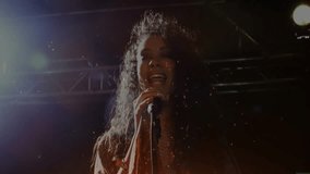 Gripping mic female singer tossing hair under spotlights releasing particles in music performance. Concert, performance, vocal, stage, entertainment, emotion, dynamic - Powered by Shutterstock - Get 15% off with code: PIKWIZARD15