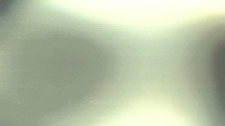 Abstract footage with a subtle, shimmering metallic texture. The light softly moves across the surface, creating a smooth, elegant, and modern visual with a hint of retro film grain and color shift.