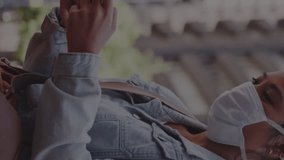 Animation of macro Coronavirus cells spreading over a woman wearing a face mask using smartphone in city street. Coronavirus Covid 19 pandemic social distancing concept digitally generated composite. - Powered by Shutterstock - Get 15% off with code: PIKWIZARD15