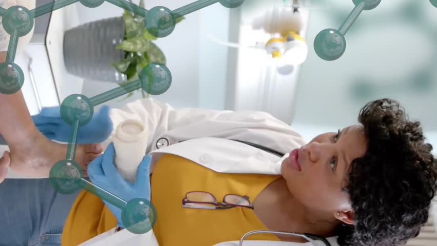 Animation of element structure over african american female doctor bandaging leg of girl patient. Digital interface, connection, hospital and healthcare, digitally generated video. - Powered by Shutterstock - Get 15% off with code: PIKWIZARD15