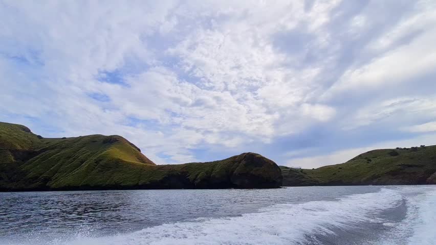 landscape footage of sea wave becouse speed boat machine on. speed boat moving with beautiful hills of padar island labuan bajo at east nusatenggara archipilago.