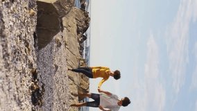 Couple walking on rocky beach with colorful wave animation overlay. Seaside, vacation, digital, coastline, romance, nature - Powered by Shutterstock - Get 15% off with code: PIKWIZARD15