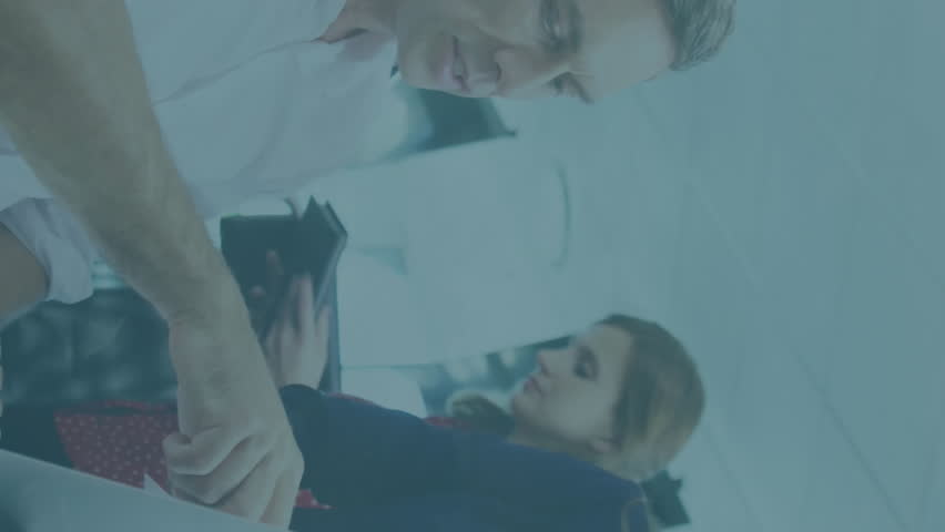 Animation of financial data processing against diverse colleagues discussing over a laptop at office. Global finance and business technology concept - Powered by Shutterstock - Get 15% off with code: PIKWIZARD15