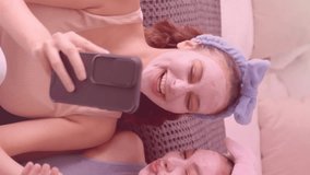 Heart icons animation over two women with face masks laughing and using smartphone. Social media, pandemic, friendship, laughter, technology, connection - Powered by Shutterstock - Get 15% off with code: PIKWIZARD15