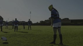 Sports analytics graphs overlaying pitch guiding rugby kicker in green cap kicking ball. Athletics, teamwork, performance, competition, training, youth, outdoor - Powered by Shutterstock - Get 15% off with code: PIKWIZARD15