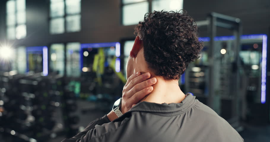 Back, hand and man with neck pain in gym, fitness injury or muscle tension with pressure. Spinal problem, sore and athlete with massage for stiffness, cramps or ache with intense exercise at center