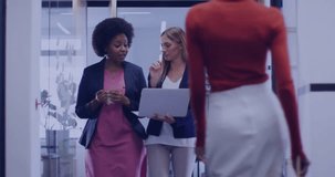 Businesswomen entering glass corridor starting AR charts overlay during joint data review session. Collaboration, teamwork, innovation, professionalism, technology, digital, diversity - Powered by Shutterstock - Get 15% off with code: PIKWIZARD15