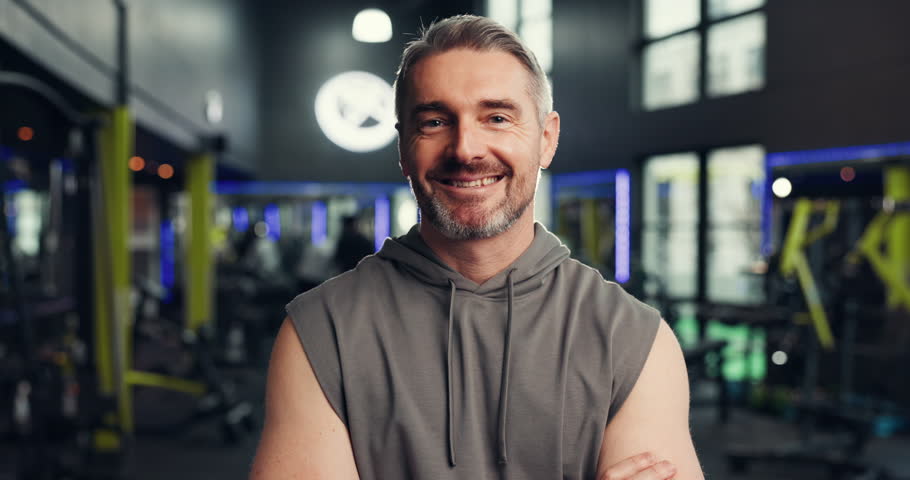 Happy, fitness and face of mature man in gym with workout, training or challenge with confidence. Smile, wellness and portrait of male athlete from London with pride for exercise in sports center.