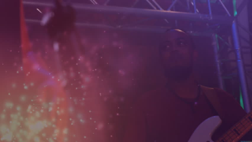 Stage sparks initiating camera shifting focus revealing musician playing bassline with LED lights. Concert, performance, lighting, stage, spectacle, entertainment, musician