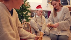 Two women and child sit on the floor in a room and create handmade decorations for Christmas tree. The girl is sneezing and her mother is laughing. Preparing for celebrating winter holiday theme - Powered by Shutterstock - Get 15% off with code: PIKWIZARD15