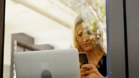 woman tapping phone and expanding network overlay on glass panel for network mapping in tech office. Technology, innovation, connectivity, digital, workspace, futuristic, communication - Powered by Shutterstock - Get 15% off with code: PIKWIZARD15