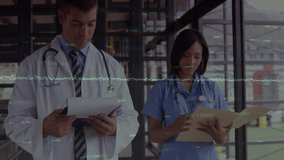 Doctor pointing chart to nurse while nurse reviewing data and generating medical data overlays. Medical staff, healthcare, collaboration, professionalism, technology, clinical environment, teamwork - Powered by Shutterstock - Get 15% off with code: PIKWIZARD15