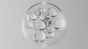 Abstract cosmetic background with glass spheres and bubbles inside a larger orb. Hyaluronic acid, serum, or the molecular structure of a hydrating essence motion science concept. - Powered by Shutterstock - Get 15% off with code: PIKWIZARD15