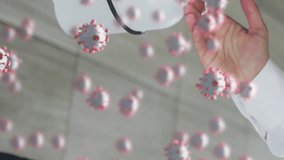 Animation of covid 19 virus cells over caucasian businessman wearing disinfecting hands. Covid 19 pandemic and digital interface concept digitally generated video. - Powered by Shutterstock - Get 15% off with code: PIKWIZARD15