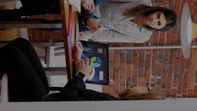 Animation of icons in circles over multiracial coworkers discussing report over laptop in office. Digital composite, multiple exposure, teamwork, finance, business, communication and technology. - Powered by Shutterstock - Get 15% off with code: PIKWIZARD15