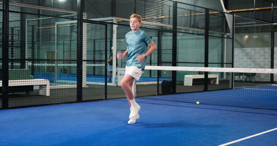 Boy, teenager and fitness with training in padel court for workout, exercise or physical activity. Male person, running and endurance with warm up or preparation for indoor tennis or sport practice
