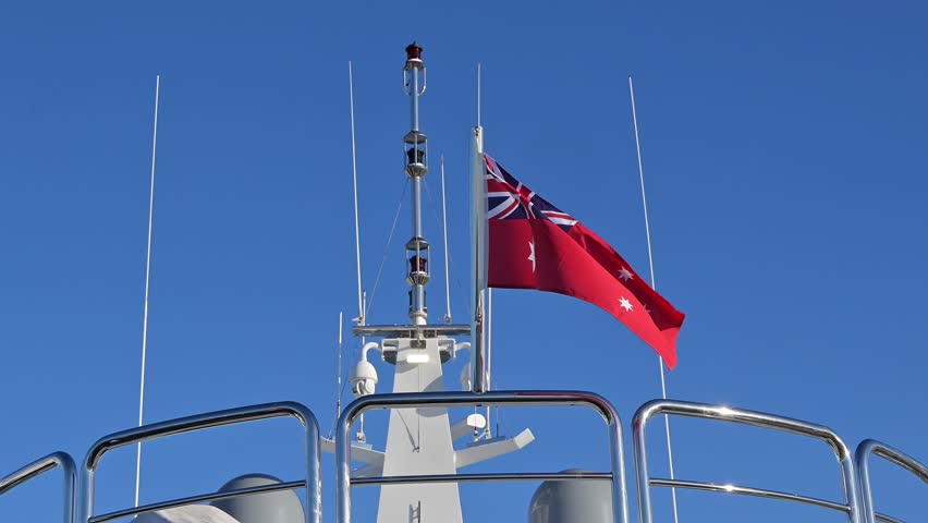 Australian red ensign flag, official merchant ship maritime symbol, fluttering on mast of boat	
