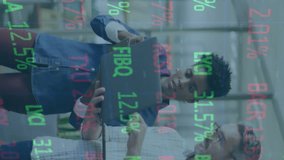 Animation of trading board over diverse coworkers standing with laptop and discussing reports. Digital composite, multiple exposure, teamwork, technology and stock market concept. - Powered by Shutterstock - Get 15% off with code: PIKWIZARD15