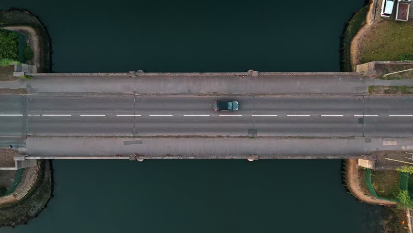 Aerial Birds Eye View Of Bridge Over River At Sunset With Cars Passing Over