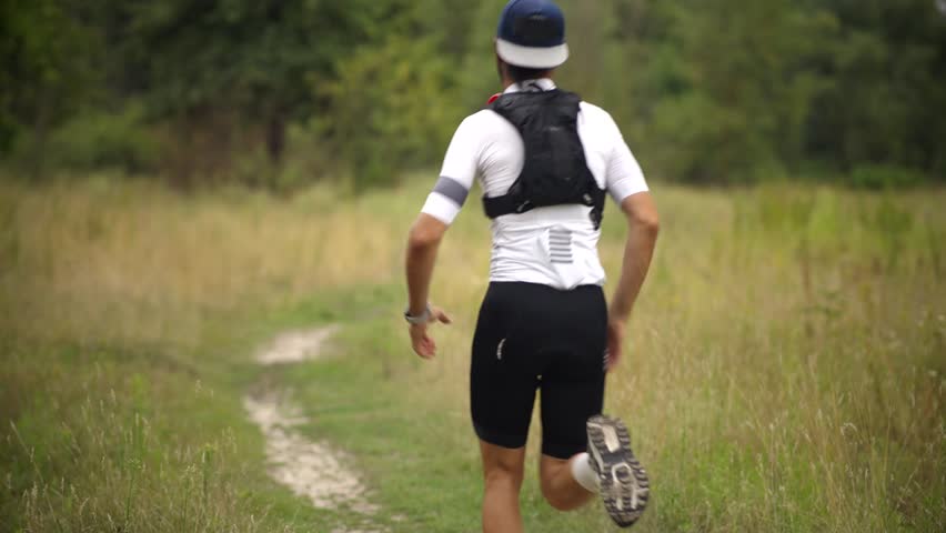 Fitness Training. Endurance Sport. Male Runner Running. Trail Running Adventure. Hydration Pack Fitness Progress. Exercise Routine Recreational Sport. Active Living Sportswear And Gear.Countryside Run